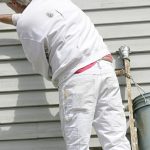 Exterior painting of a home by worker on a ladder