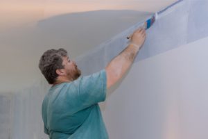 Interior Painter painting edges of ceiling